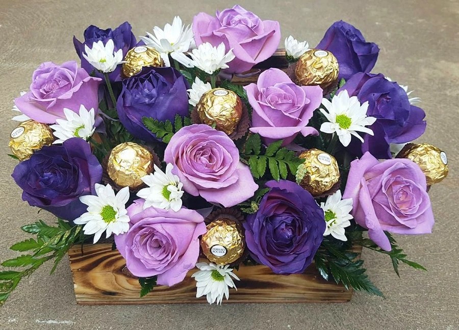 Arreglo artesanal de rosas lilas, rosas moradas, margaritas y chocolates